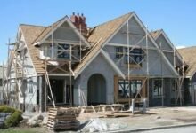 A house under construction, featuring scaffolding and wooden beams, showcasing the building process.