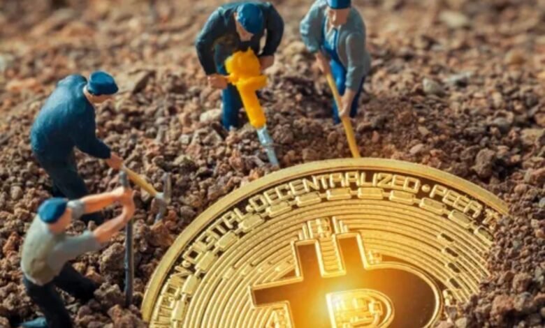 Miniature figures excavate dirt in search of a bitcoin, illustrating the concept of cryptocurrency mining.