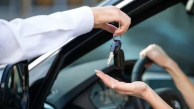 A man is handing a car key to a woman, symbolizing a transfer of responsibility or ownership.