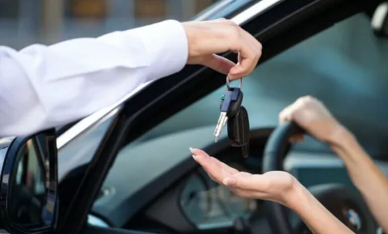 A man is handing a car key to a woman, symbolizing a transfer of responsibility or ownership.